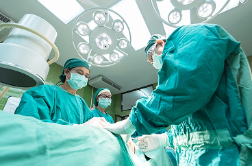 Groupe de médecins portant un tissu chirurgical vert et réalisant une opération chirurgicale critique